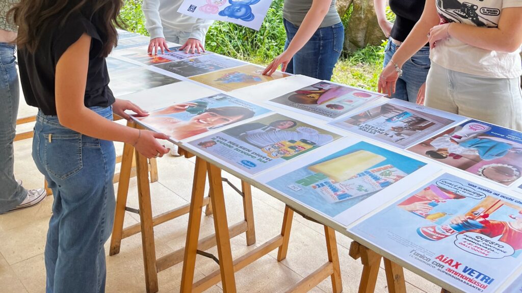 studentesse organizzano dei manifesti d'epoca con delle pubblicità di prodotti